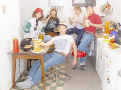 Bandphoto of Potato Beach. 5 bandmembers sitting in the kitchen.